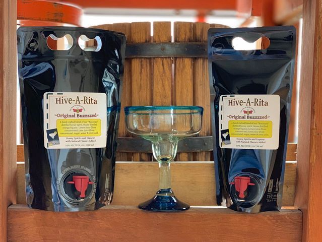 Hive A Rita Pouches and margarita glass in front of a wooden fruit press.