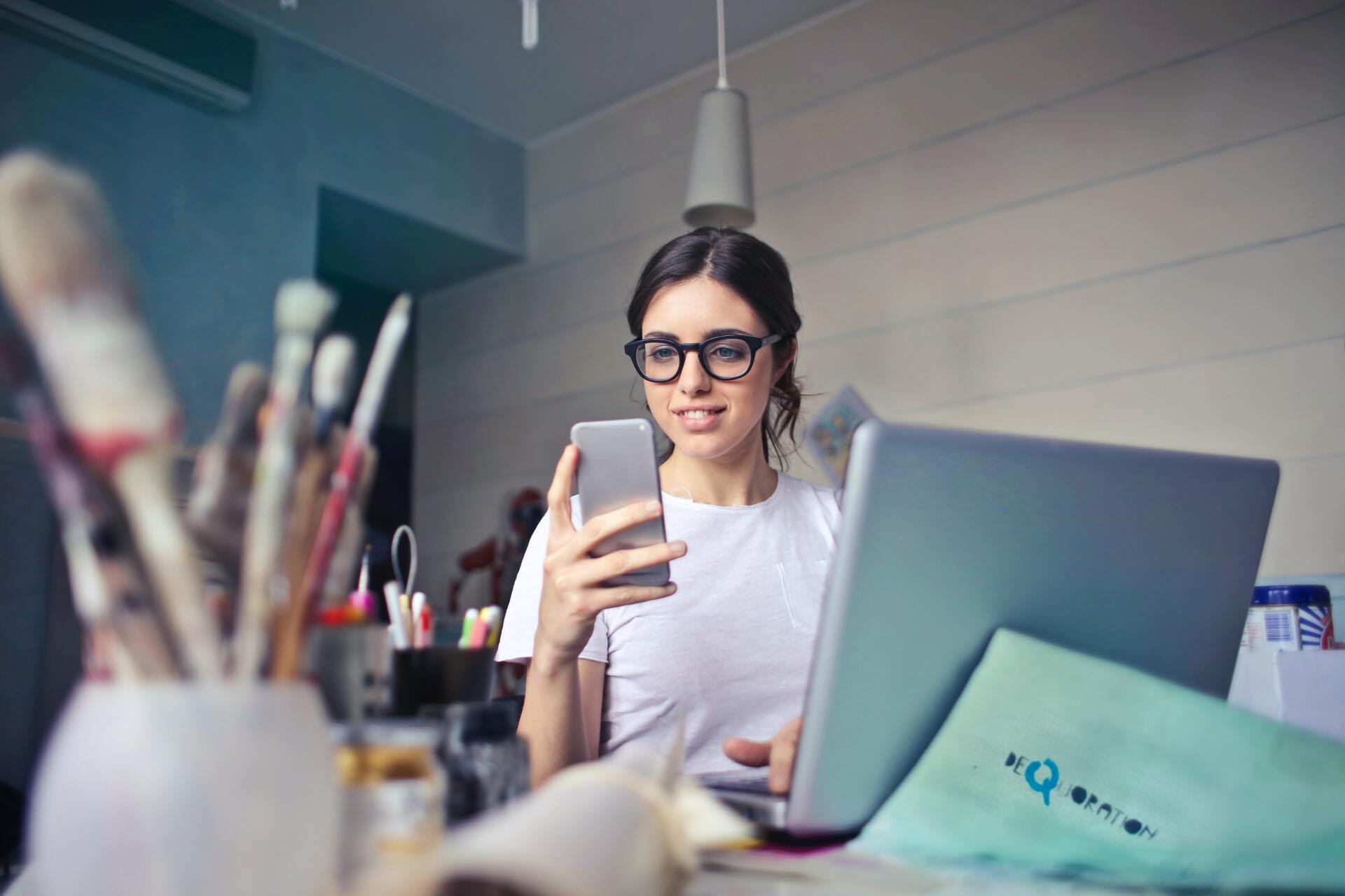 junge Frau am Smartphone in einem Atelier