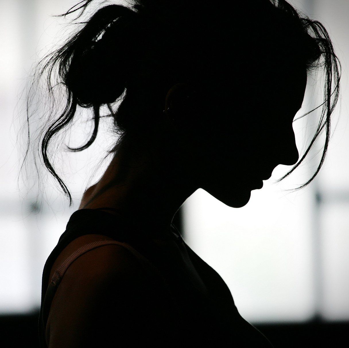 Silhouette of a woman with her head down
