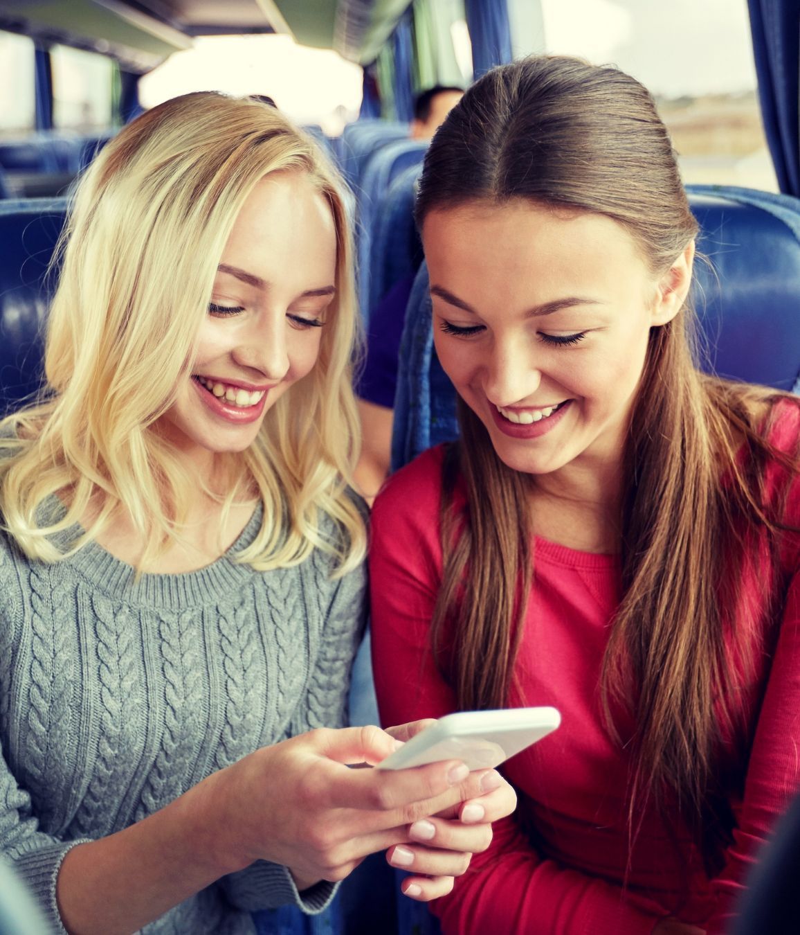 Persona con giacca di jeans che utilizza un’app di prenotazione viaggi su smartphone