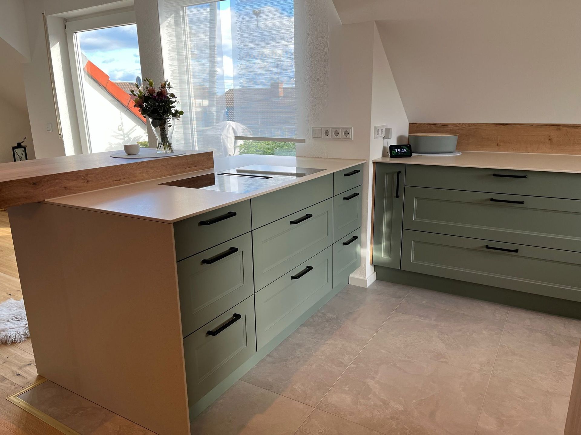 Verleihen Sie Ihrer Küche einen Hauch von Eleganz und rustikalem Charme mit unserer Nobilia Cascada Küche im modernen Landhausstil, vervollständigt durch edle schwarze Griffe, einen großformatigen SCHOCK Spülenstein und die warme Ausstrahlung der Strasser Crema Arbeitsplatte, die ein Gefühl von spanischer Eleganz in Ihr Zuhause bringt.