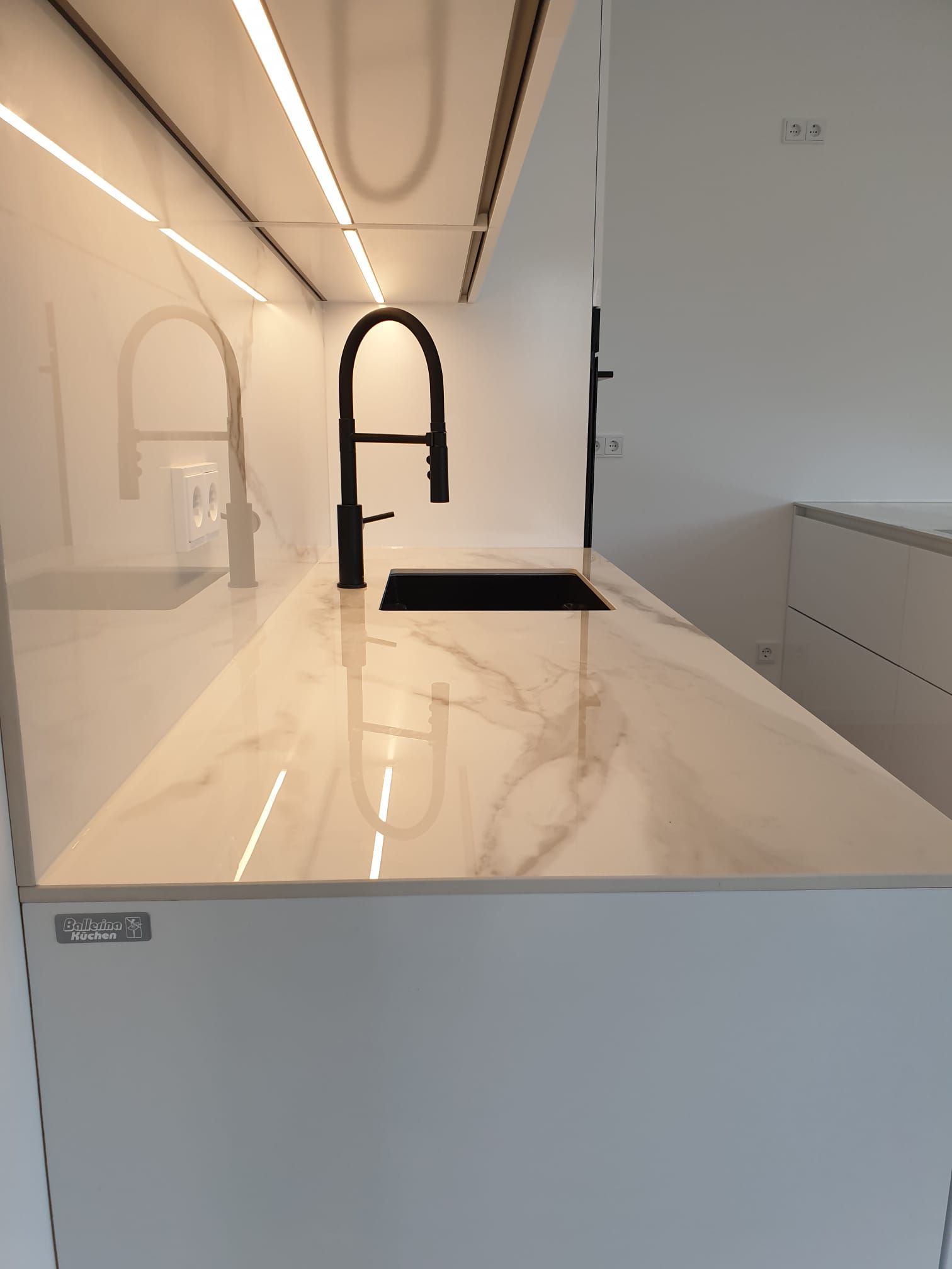 Verwöhnen Sie sich mit einer Ballerina Küche, die nicht nur mit Smartglas Hochglanz Fronten und marmorierten Keramik-Arbeitsplatten, sondern auch mit eleganten Lichtlösungen und hochwertigen Bosch accentLine Premium Einbauelektrogeräten ausgestattet ist.