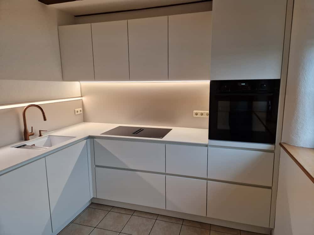 Grifflose Nobilia Küche in Weiß ultramatt mit durchdachtem Stauraum und Alba Vene Restoning Arbeitsp