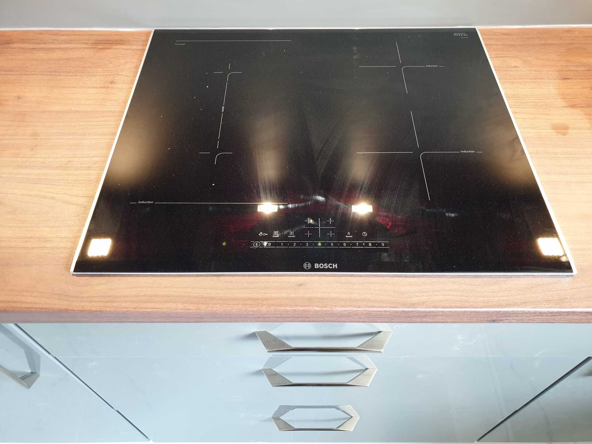 Schiefergraue Küchenfronten mit Nussbaum-Kontrast – klassisch und pflegeleicht.