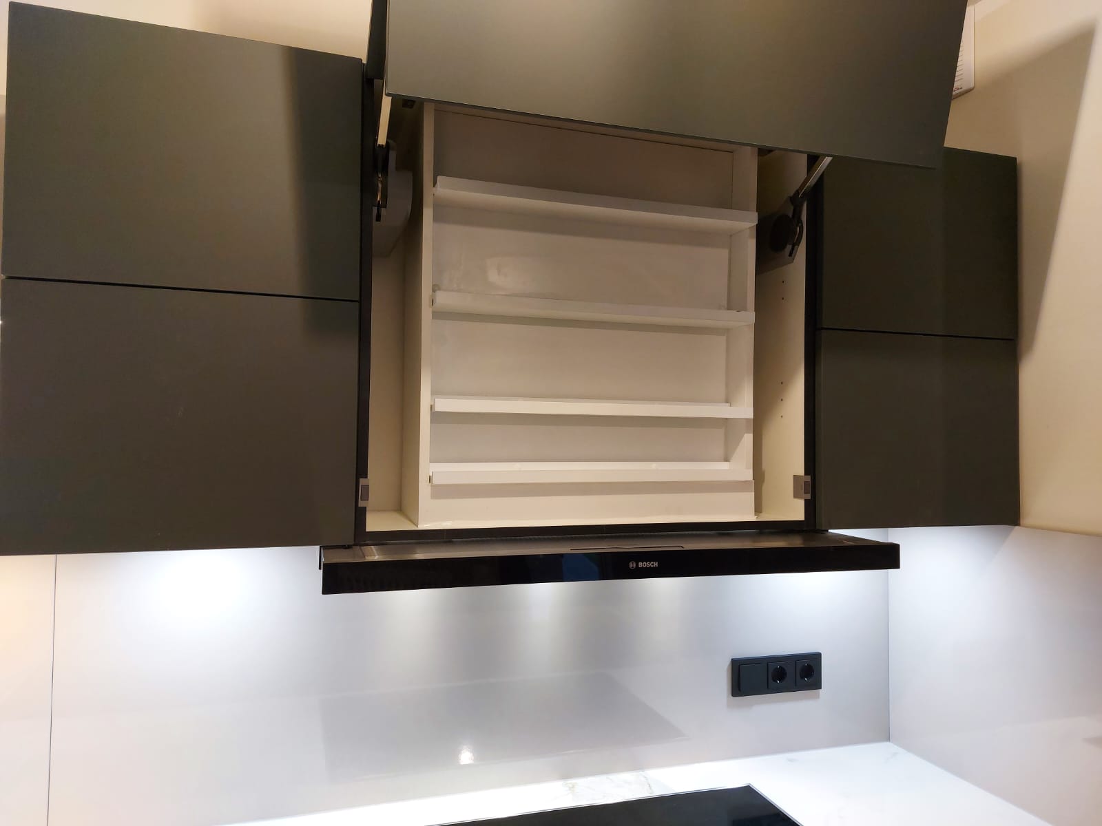 Elegante Mineralgrüne Nobilia Einbauküche in U-Form mit nahtlos eingebauten Miele und Bosch Elektrogeräten sowie einer strapazierfähigen Keramikarbeitsplatte, ideal für moderne Koch- und Wohnkonzepte.