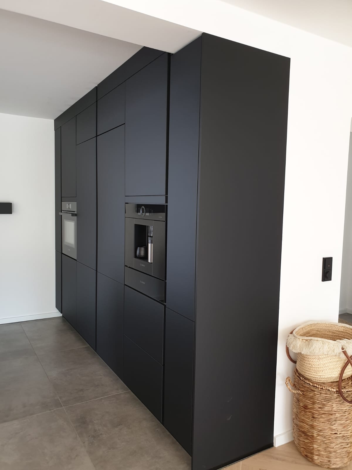 Entdecken Sie die Schönheit der Dunkelheit mit unserer Nobilia Einbauküche, die mit Antifingerprint Fronten in Schwarz und einer edlen Natursteinarbeitsplatte von Strasser in Alpengrün im Leather-Look eine zeitlose Ästhetik verkörpert.