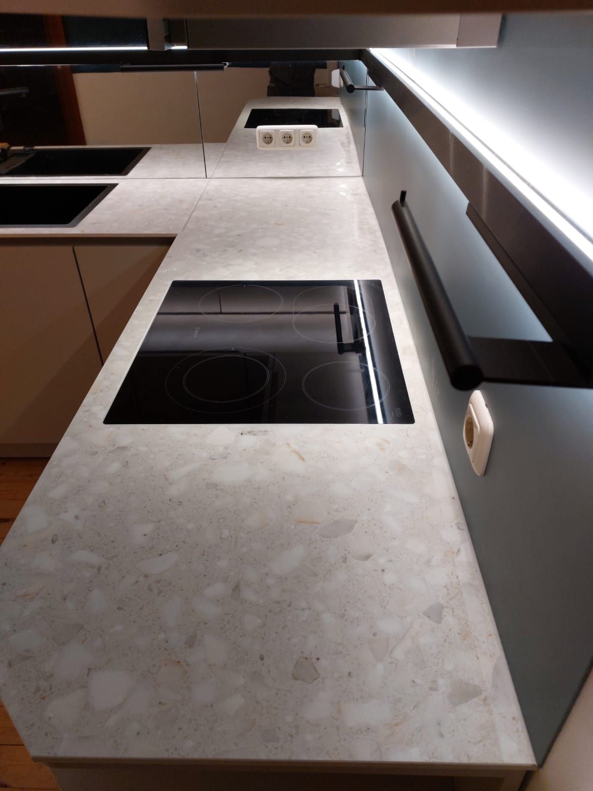 Kunstvoller Küchenraum mit Materialmix aus Keramik, Glas und matt beschichtetem Holz.