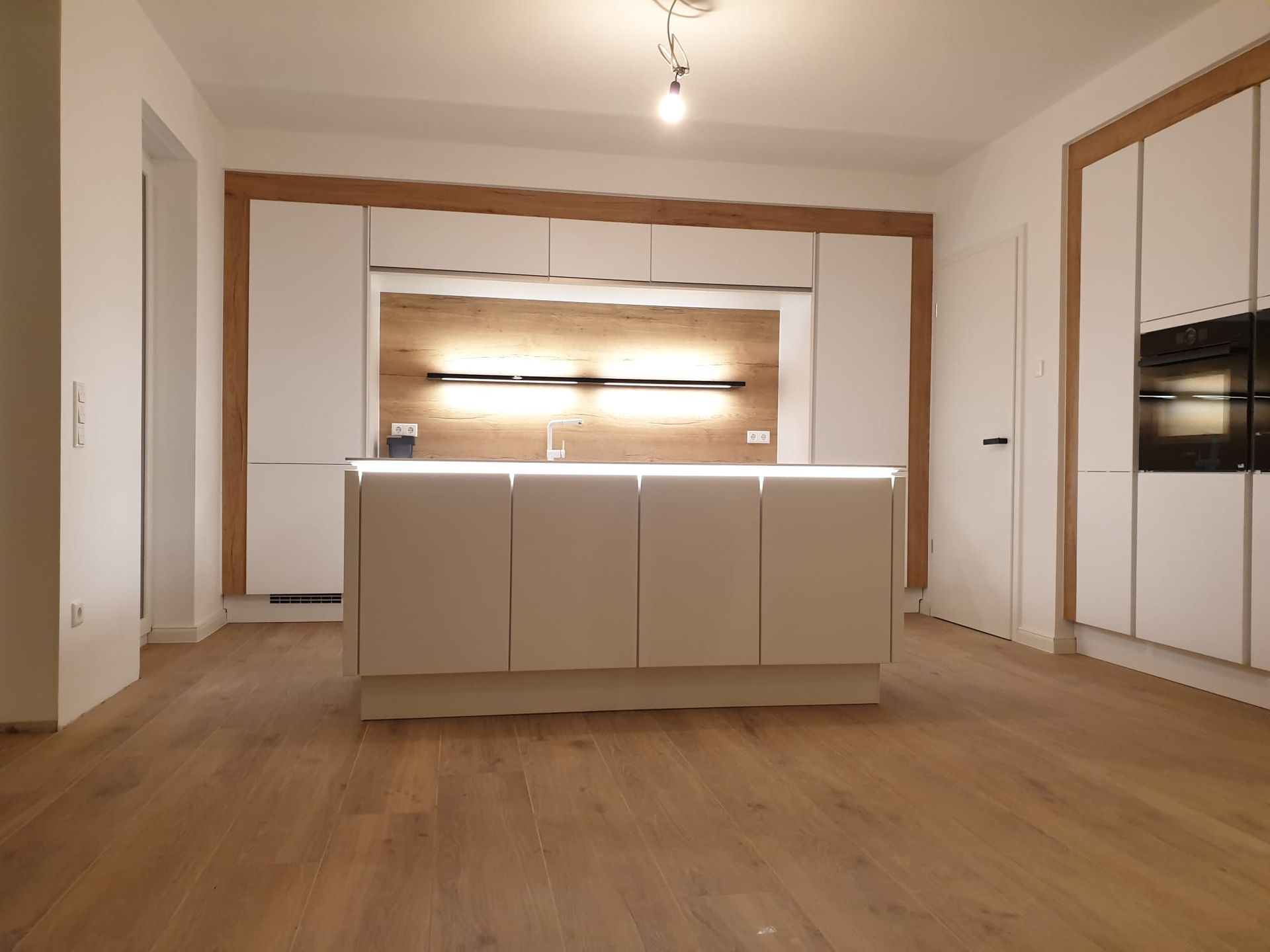 Gestalten Sie Ihre Traumküche mit einer weißen Farbpalette und setzen Sie durch raffinierte Lichtlösungen stilvolle Akzente.