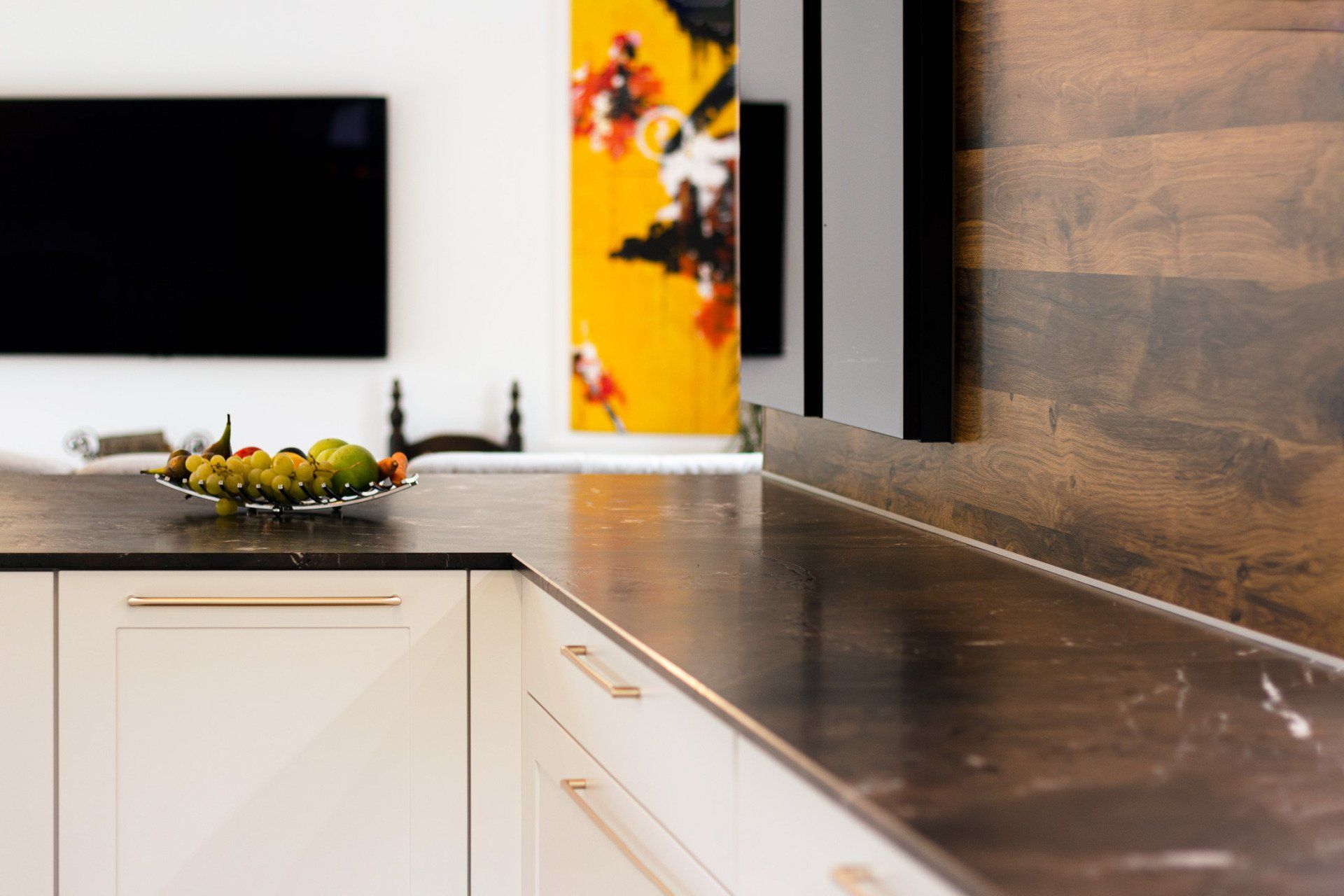 Offene Küche Kücheninsel mit Muldenlüfter und Steinarbeitsplatte Muster. Genießen Sie die Verschmelzung von Tradition und Moderne in unserer Landhaus Einbauküche mit hochmodernen dunkelglas Vitrinen. Mit einem Side-by-Side Kühlschrank, einem Smeg-Weinkühlschrank für Rot- und Weißwein, Glasauszügen und einem Blanco Drink-Soda Sprudelwasser wird Ihre Küche zu einem eleganten und funktionalen Raum.