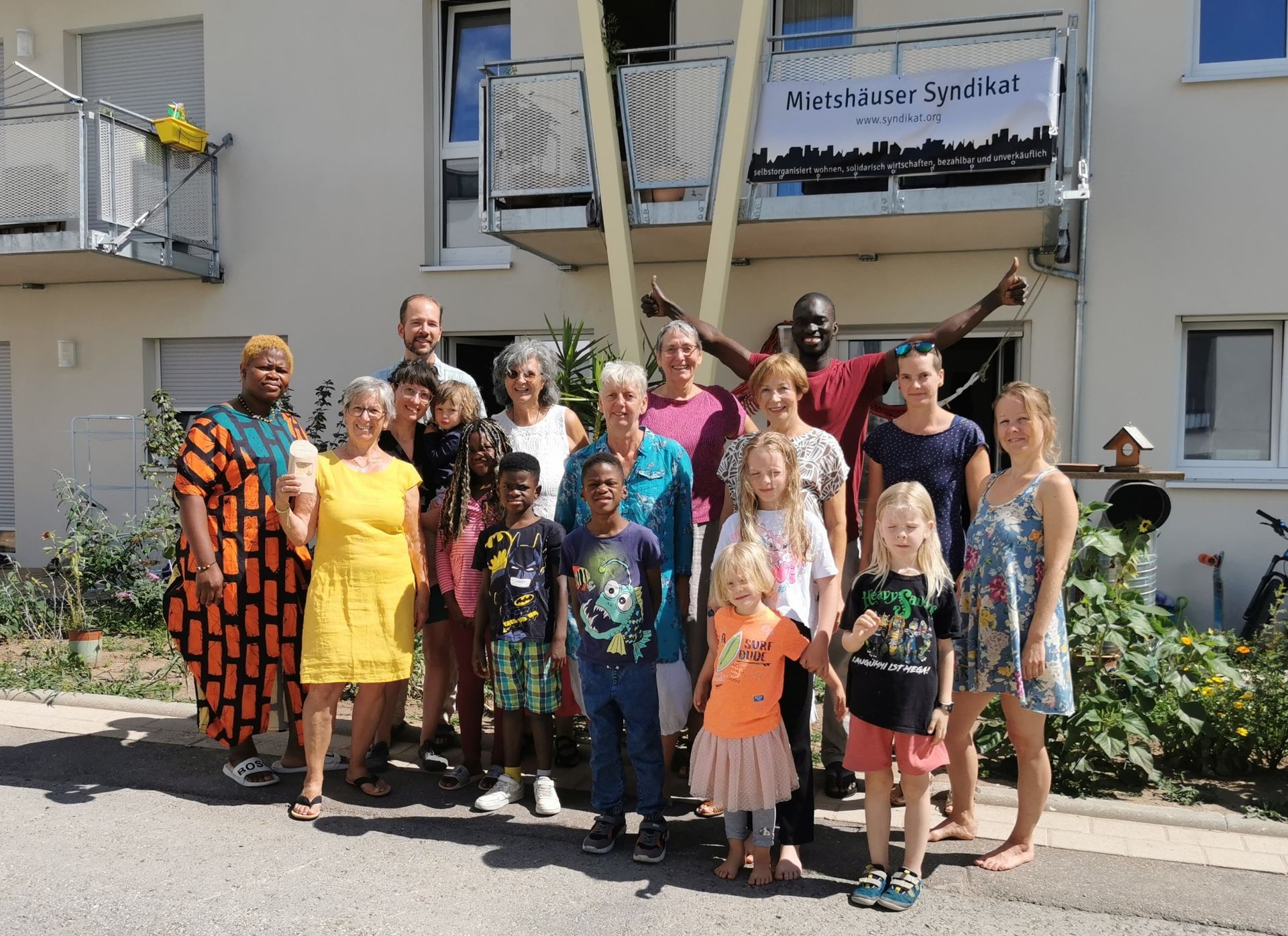 Eine Gruppe von 9 Erwachsenen und 5 Kindern lächelt in die Kamera.