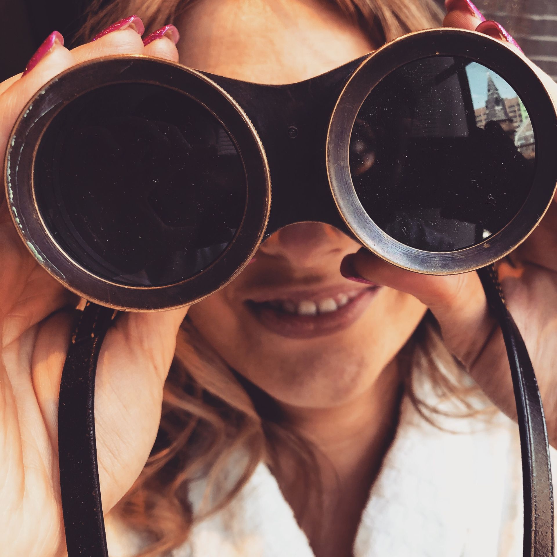 Kind oder junge Frau sieht durch ein Fernglas
