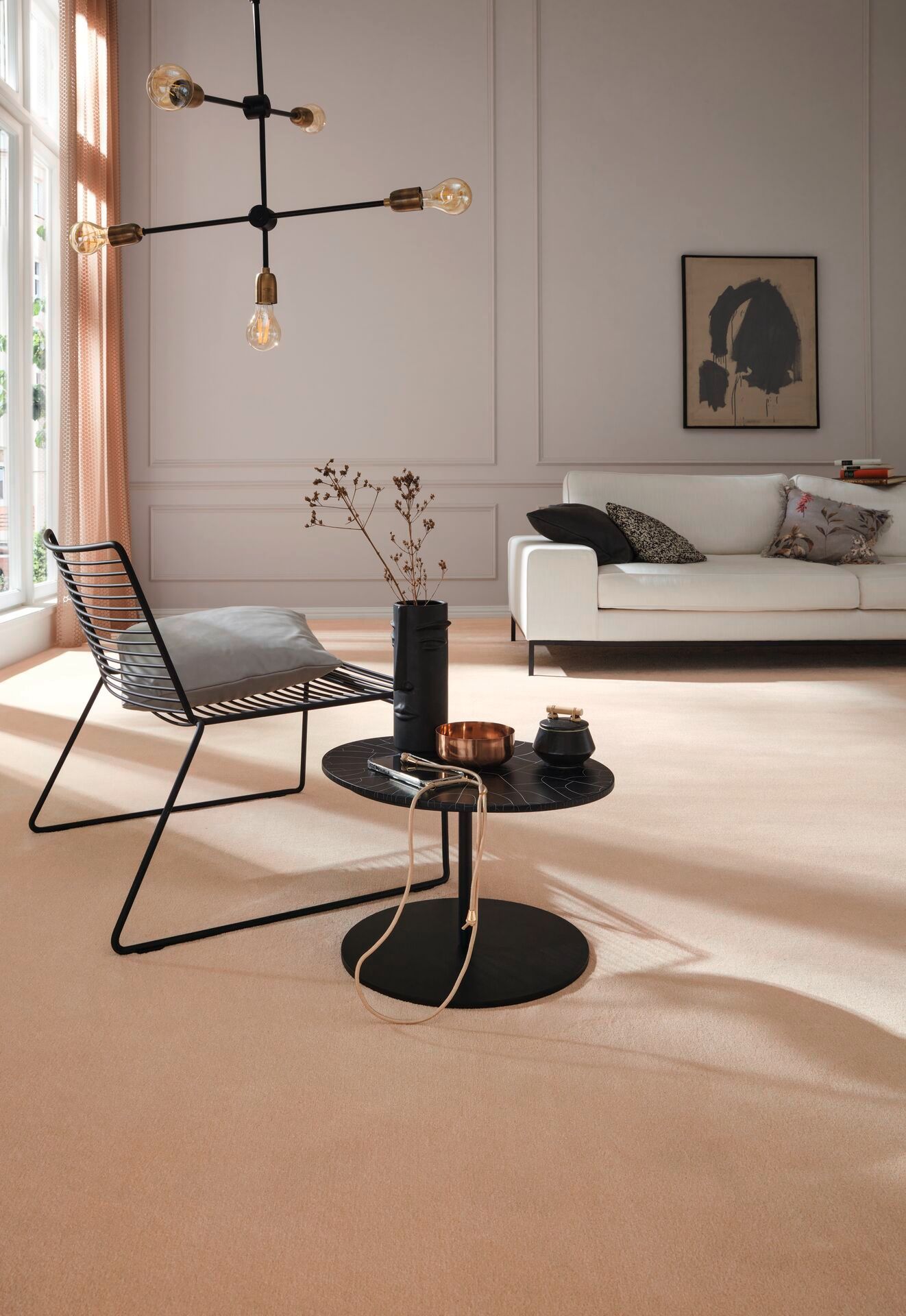 Heller Teppichboden in gemütlichem Wohnzimmer mit weißer Couch und schwarzem Designstuhl.