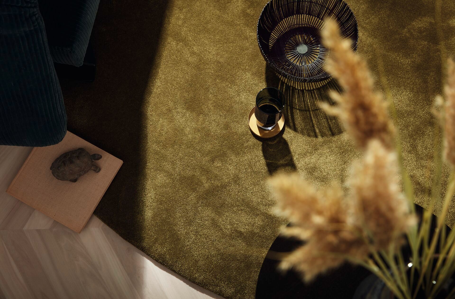 Goldener Teppich mit stilvollen Accessoires – warmes Ambiente für elegante Wohnräume.