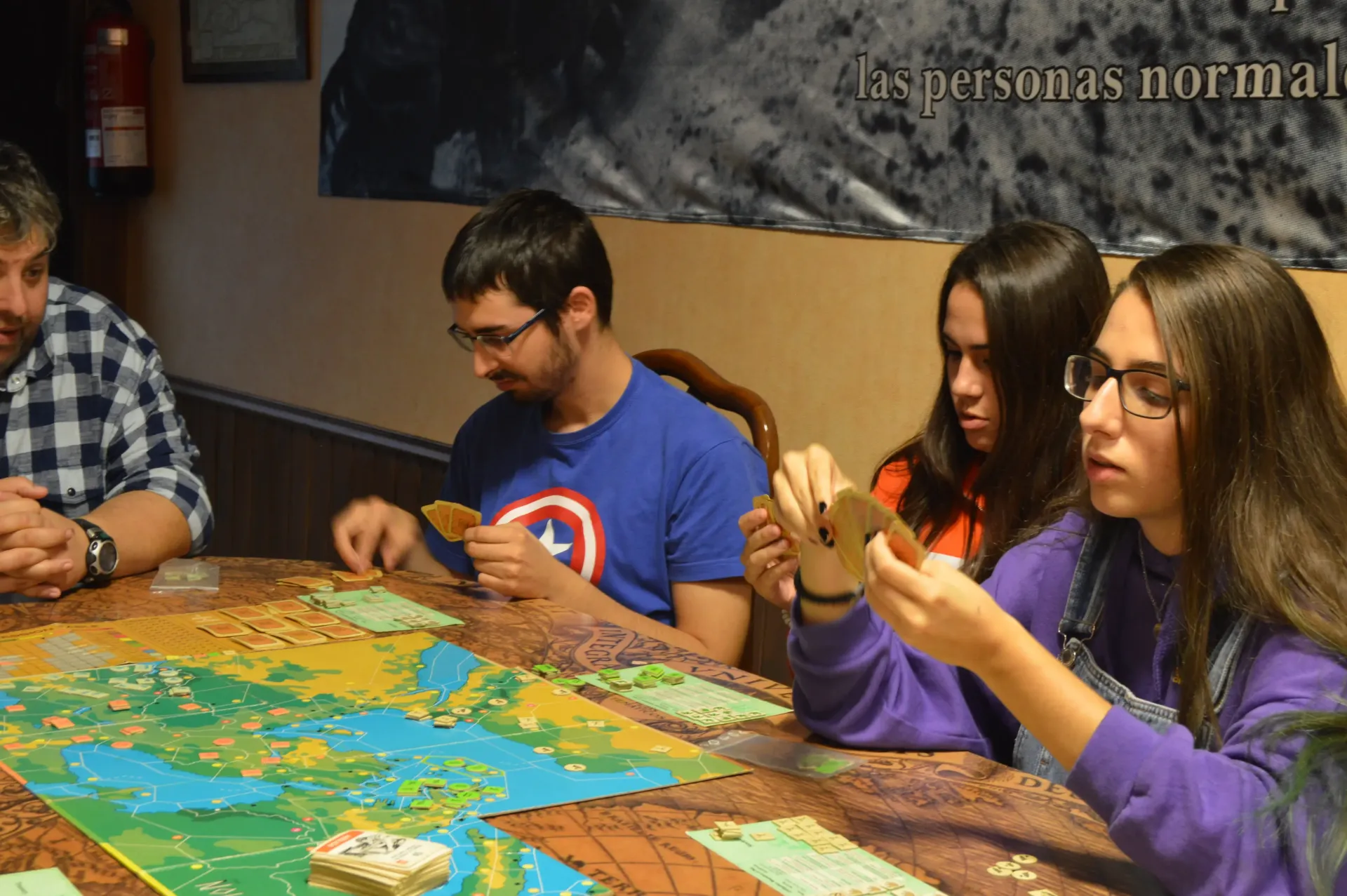 Jovenes observando cartas en una partida de juego de tablero