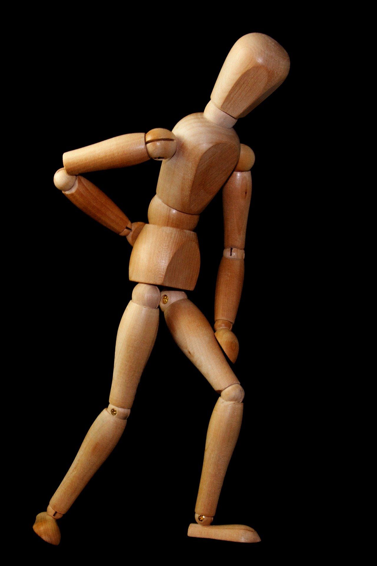 Holzfigur mit Rückenschmerzen