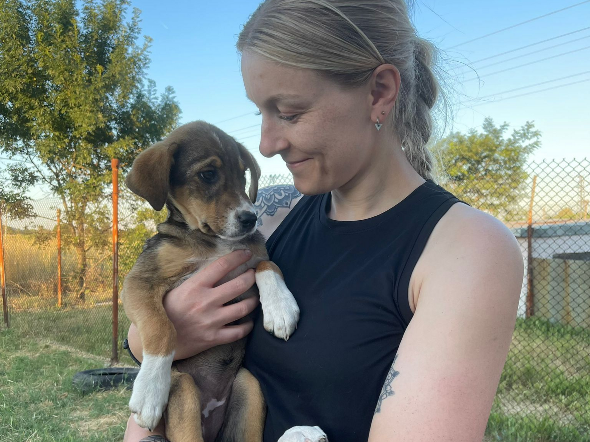 Frau mit Hundewelpen auf dem Arm