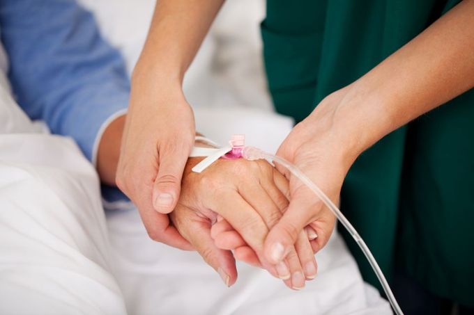 a nurse holding a patients hand