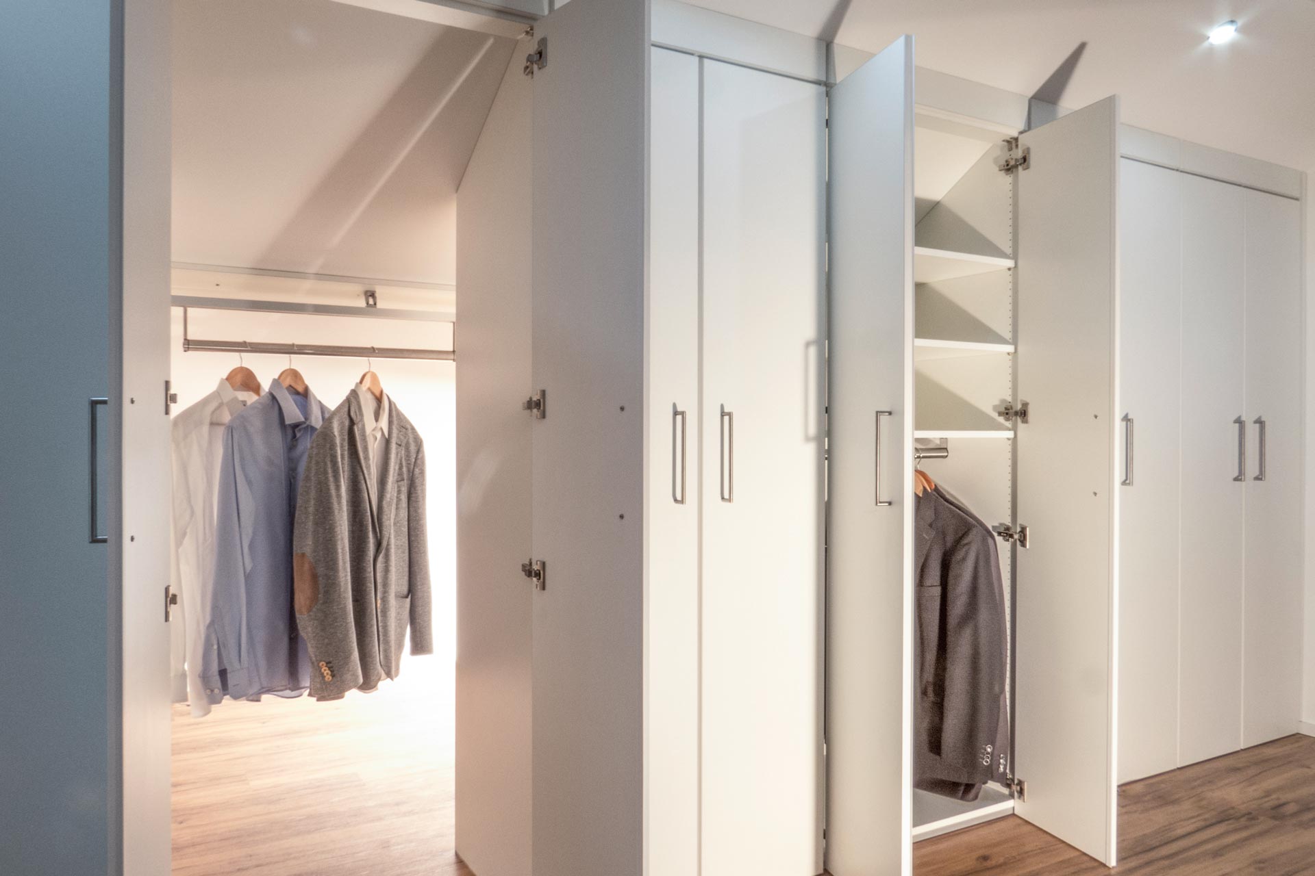 Der dressglider, die verschiebbare Kleiderstange, hinter einem Schrank unter einer Dachschräge Der dressglider, die verschiebbare Kleiderstange, hinter einem Schrank unter einer Dachschräge