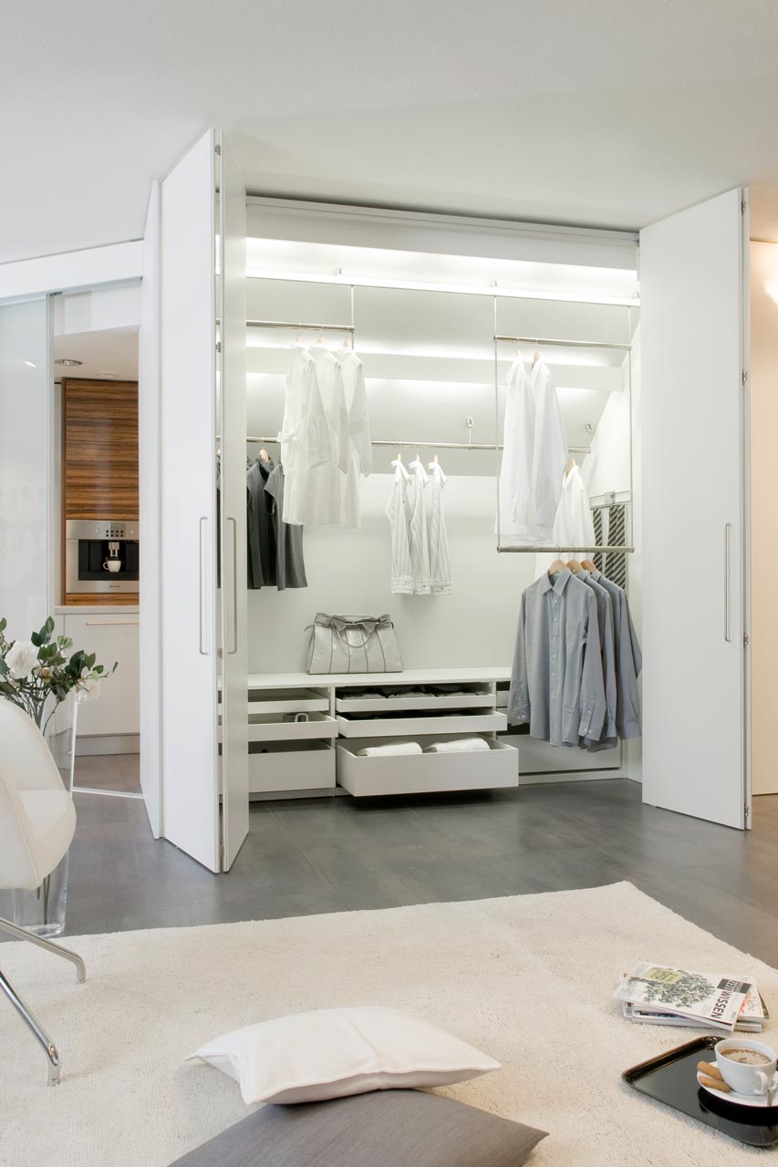 Der dressglider, die verschiebbare Kleiderstange, hinter Falttüren unter einer Dachschräge Der dressglider, die verschiebbare Kleiderstange, hinter Falttüren unter einer Dachschräge