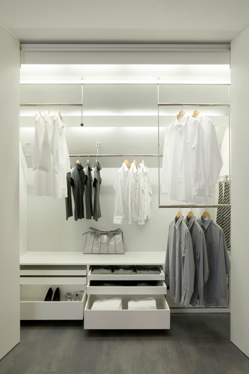 Der dressglider, die verschiebbare Kleiderstange, hinter Falttüren unter einer Dachschräge Der dressglider, die verschiebbare Kleiderstange, hinter Falttüren unter einer Dachschräge