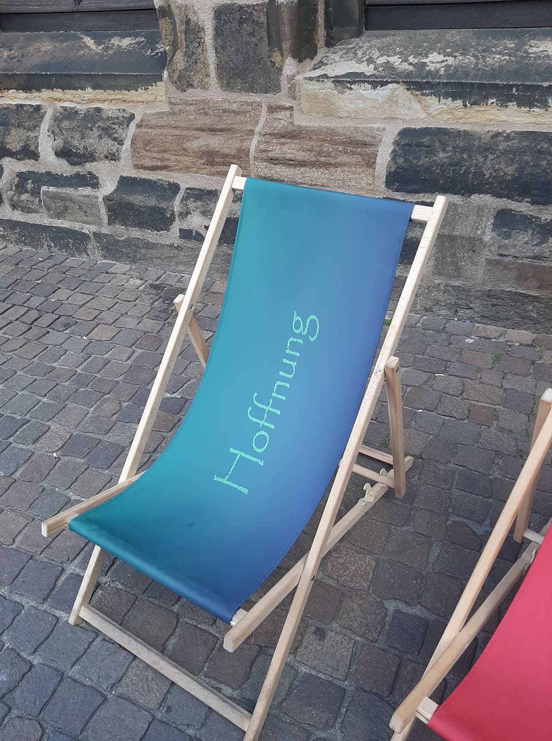 Klappstuhl, blau bespannt mit der Aufschrift