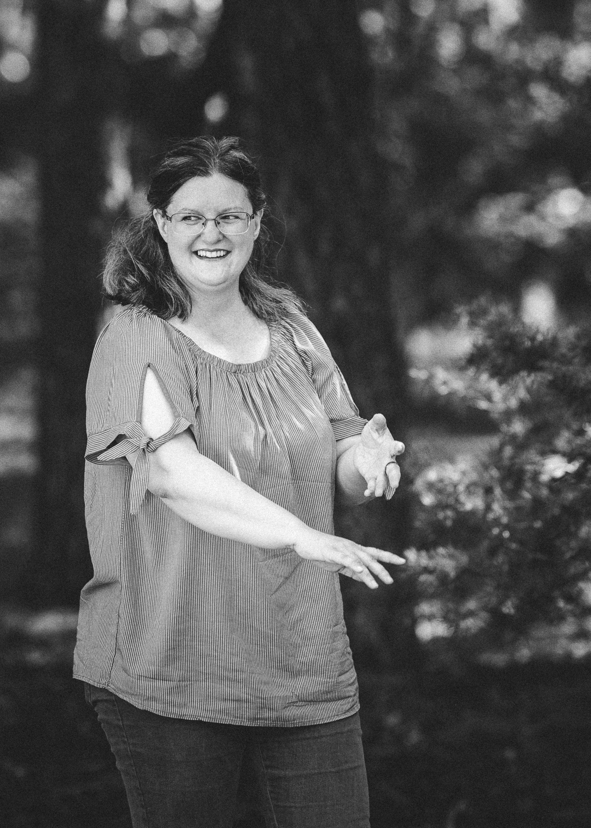 Autorin D. K. Berg ist fröhlich und wirft mit Tannenzapfen.