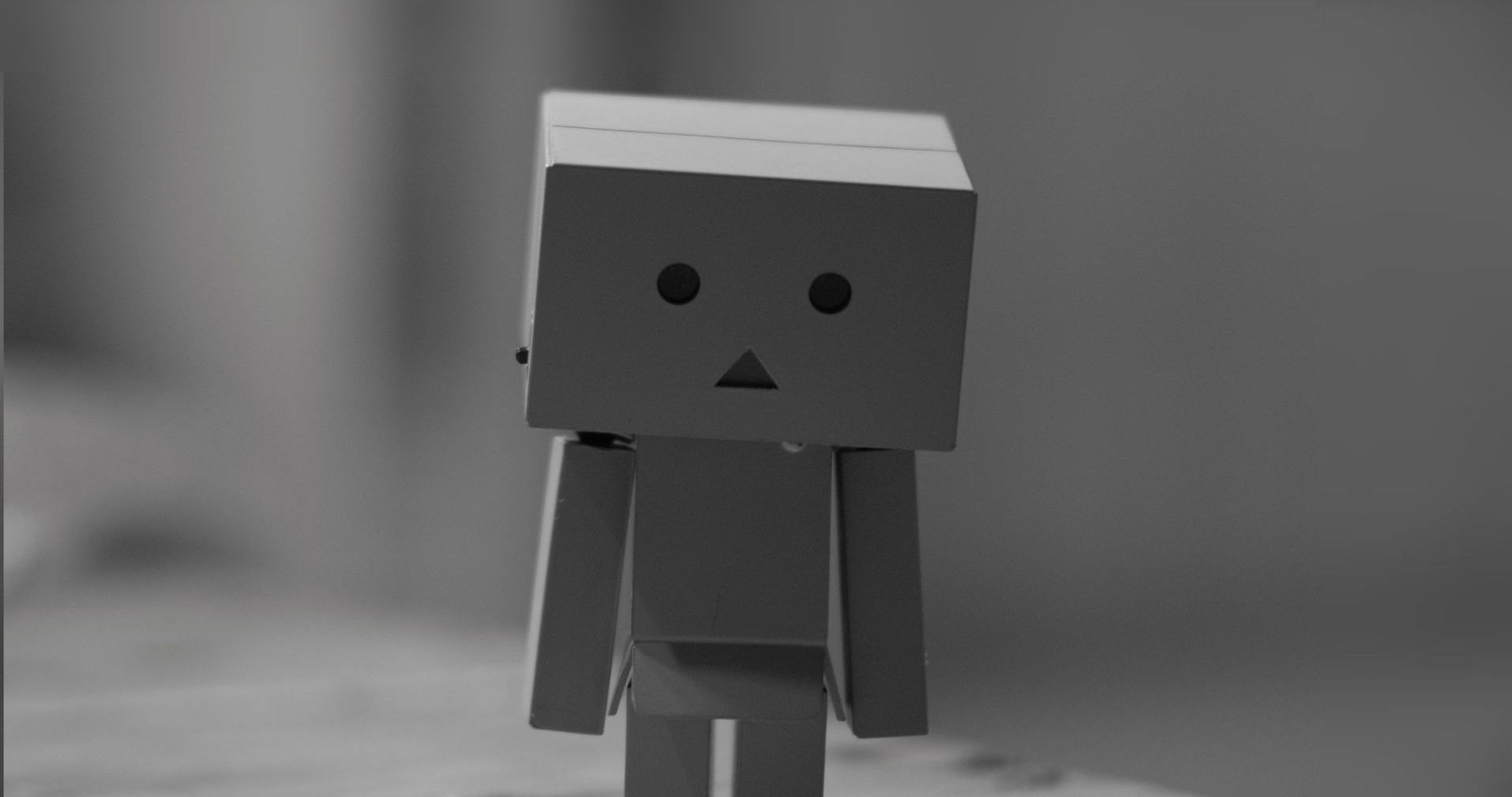 Kleiner Roboter aus Pappe schaut unglücklich