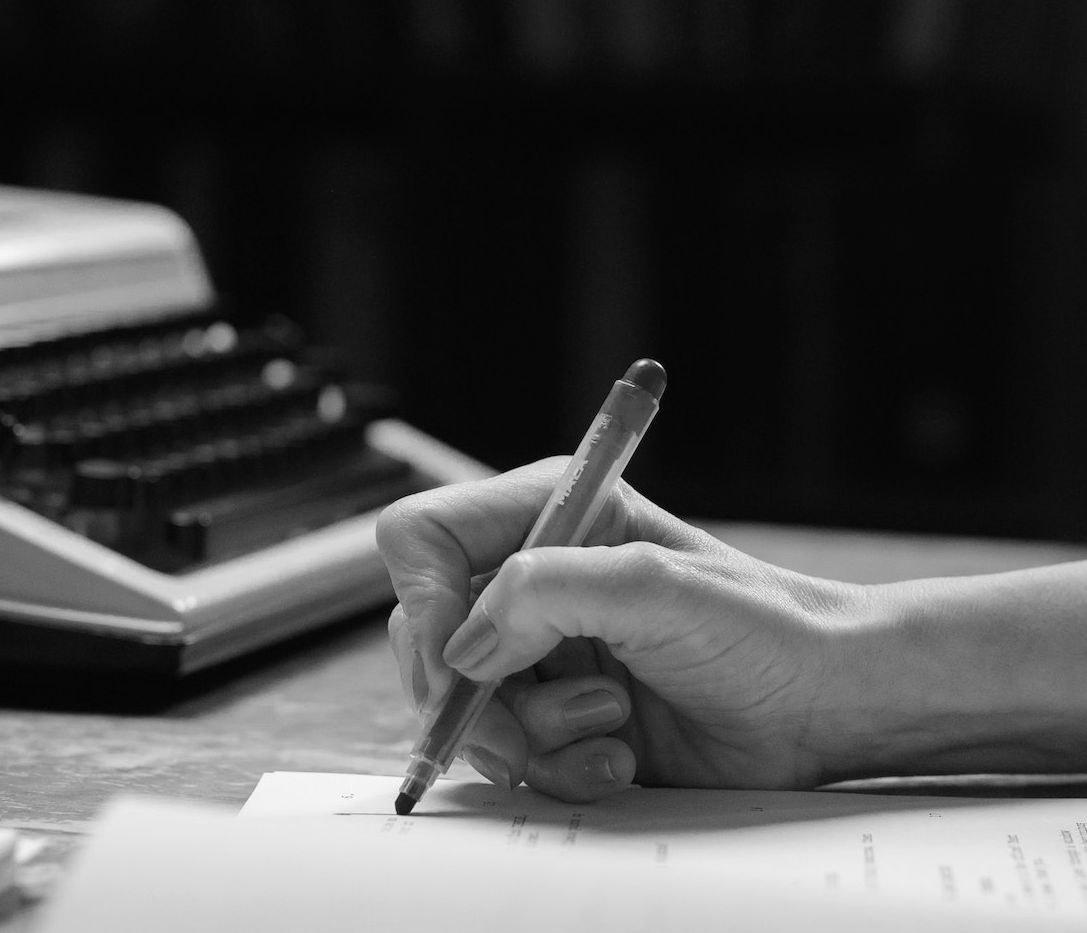 Händische Textkorrektur, eine Schreibmaschine ist im Hintergrund