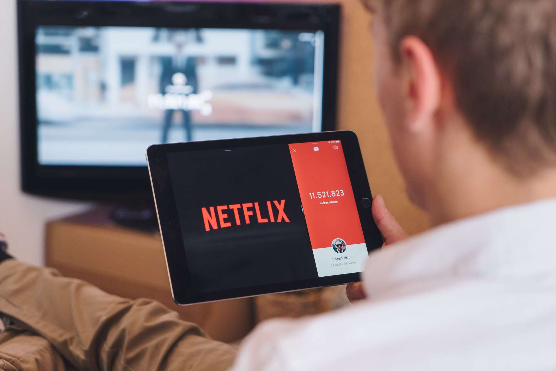 Photo by CardMapr on Unsplash Mann schaut Fernsehen und Netflix parallel