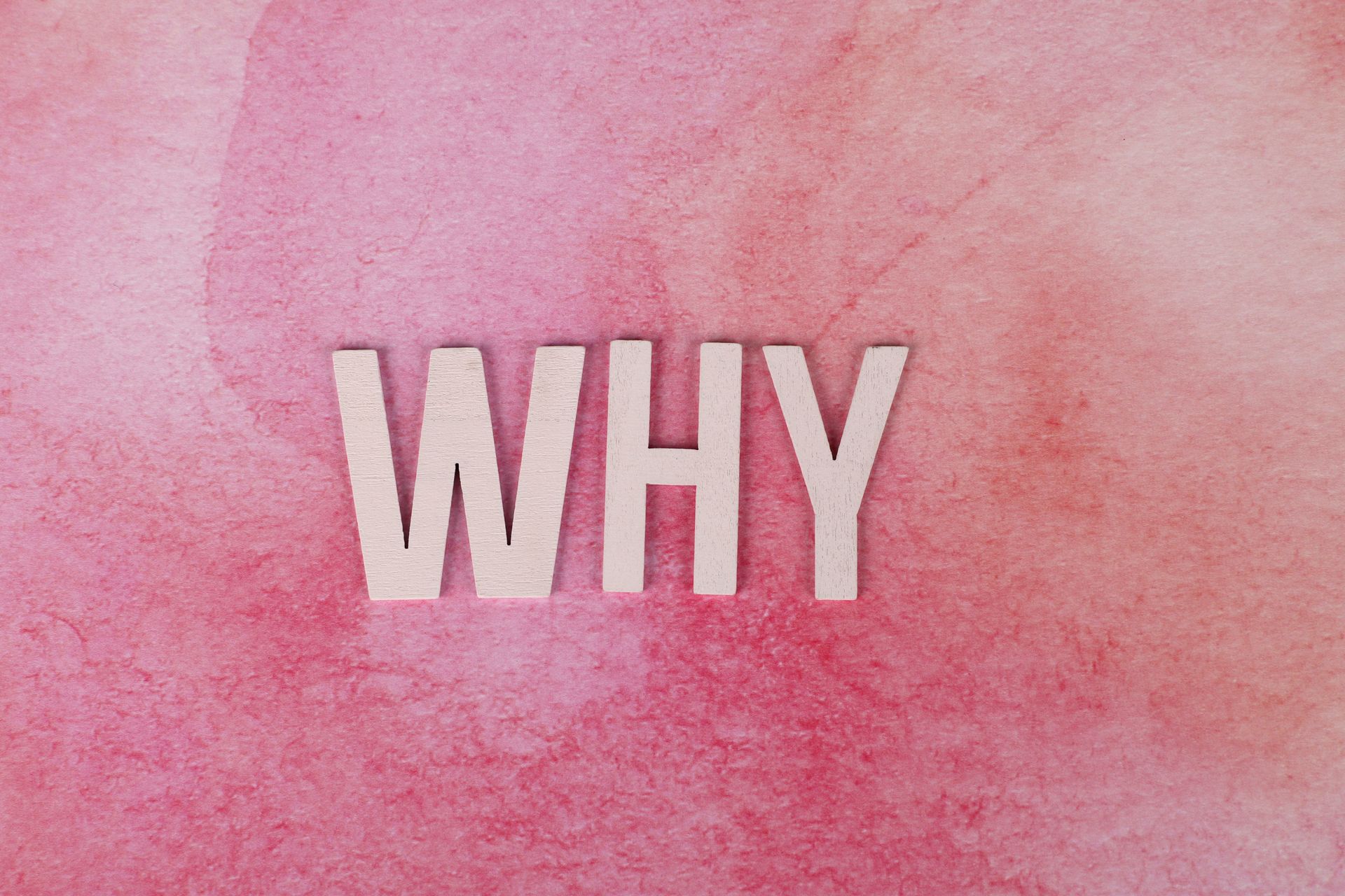 The word Why against a pink water colour background.