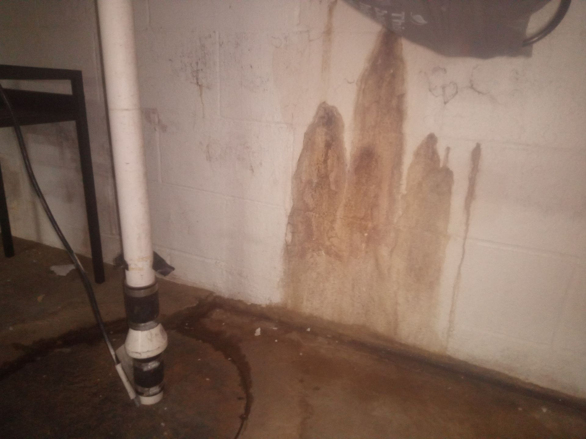 Water stains next to drain tile sump baskett.