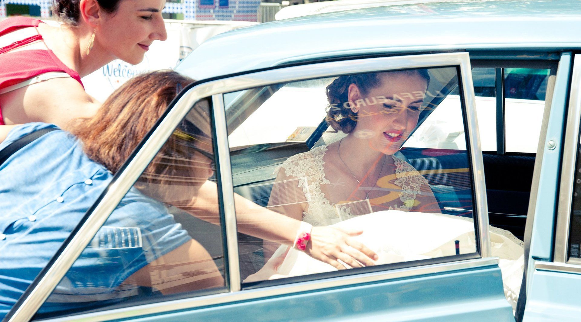 Photographie de mariage de Elizabeth Perrot Photo. Arrivée de la mariée devant l'église avec une voiture de collection. Mariage à Saint-Etienne, Loire, Rhône Alpes, France.