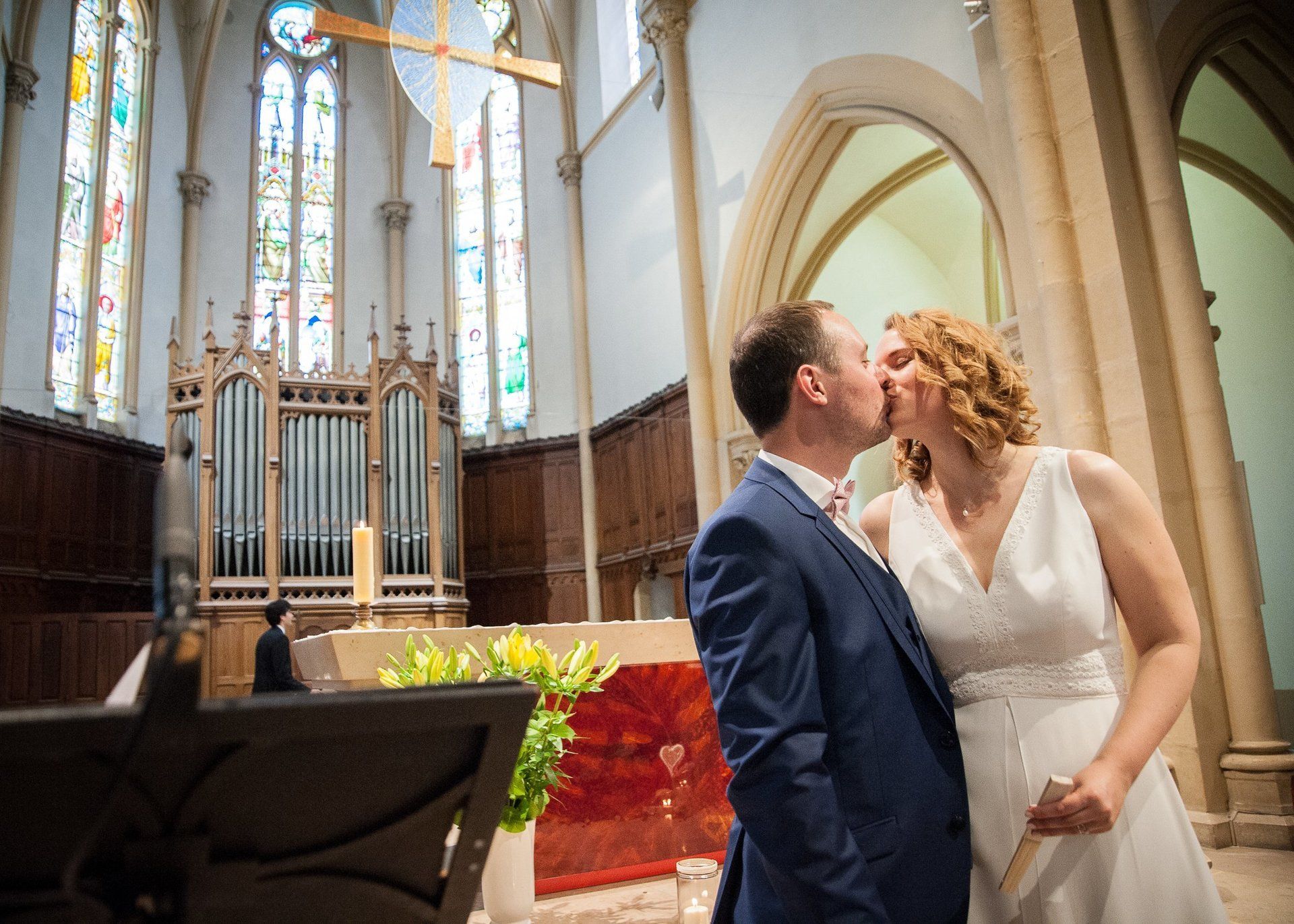 Photographie de mariage de Elizabeth Perrot Photo. Cérémonie religieuse, les mariés dans l'église, échange de baiser par les mariés. Mariage à Roanne, Loire, Rhône Alpes, France.
