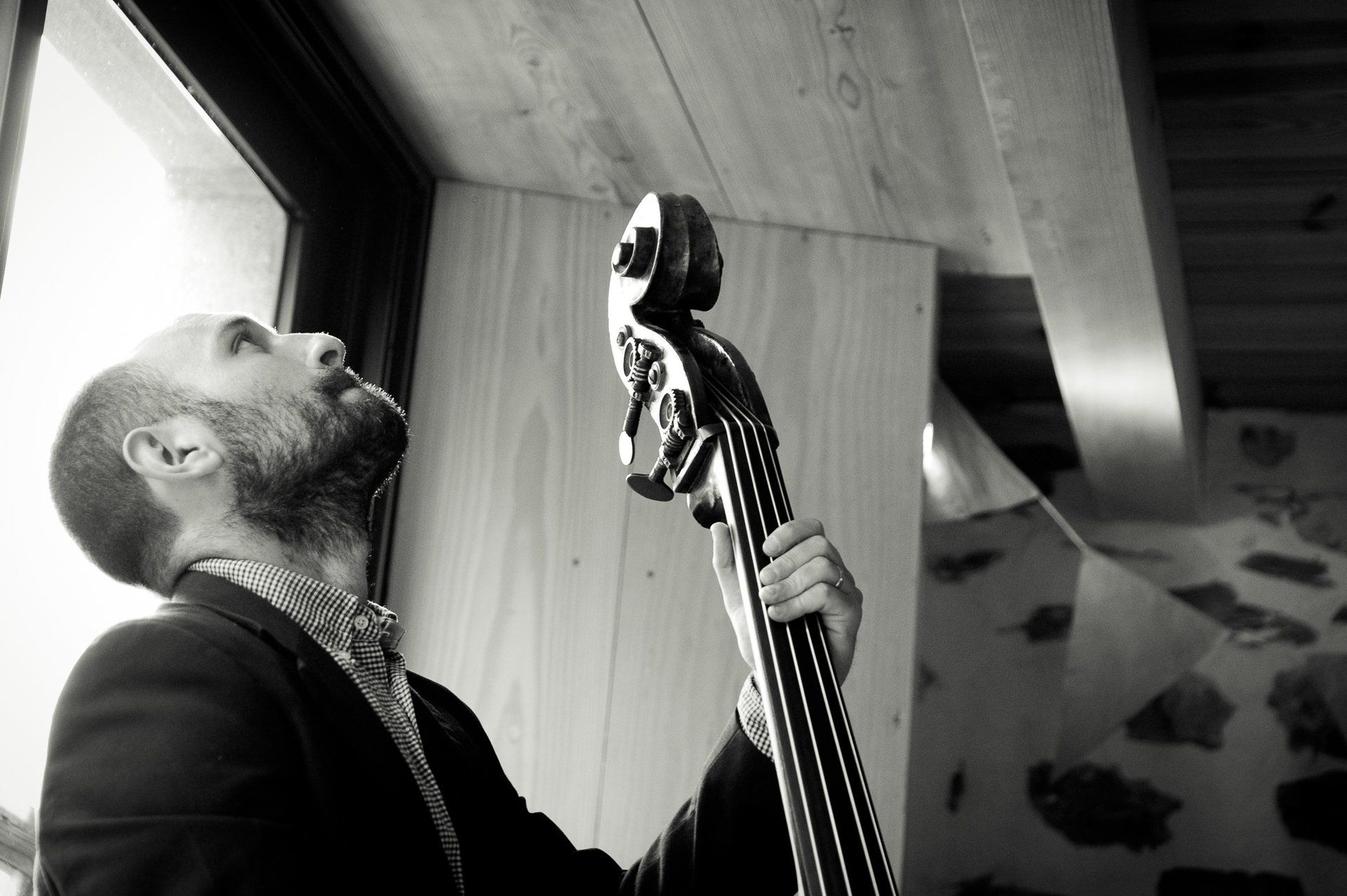 Photographie de mariage de Elizabeth Perrot Photo. Un musicien joue de la contrebasse. Groupe de musique et animation musicale acoustique pendant le cocktail. Mariage à Saint-Etienne, Loire, Rhône Alpes, France.