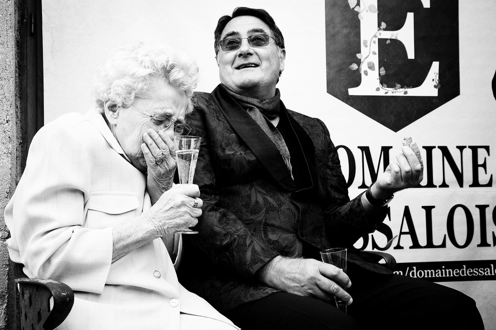 Fou rire d'une invitée durant un cocktail de mariage. Portrait d'un invité au cours du cocktail de mariage. Reportage photo de mariage de Elizabeth Perrot Photo. Shooting en exterieur. Mariage au domaine d'Essalois, aux alentours de  Saint-Etienne, Loire, Rhône-Alpes, France.