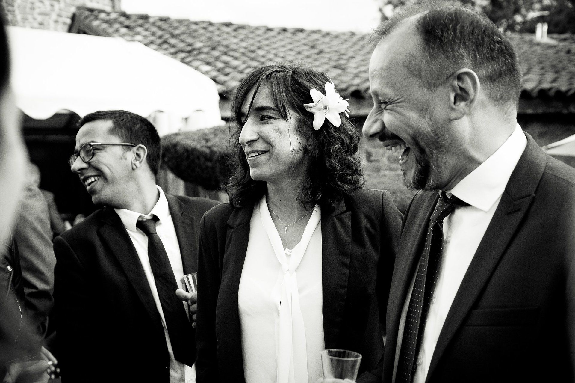 Fou rire entre le marié et les invités durant un cocktail de mariage. Les invités boivent du champagne au cours du cocktail de mariage. Reportage photo de mariage de Elizabeth Perrot Photo. Shooting en exterieur. Mariage au domaine d'Essalois, aux alentours de  Saint-Etienne, Loire, Rhône-Alpes, France.