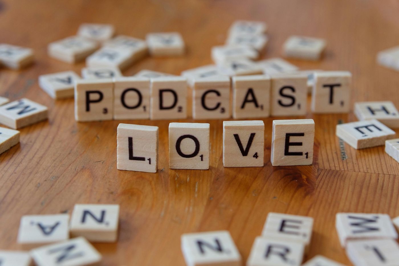 Scrabble-Steine formen die Wörter Podcast und Love – Corporate Podcast Produktion