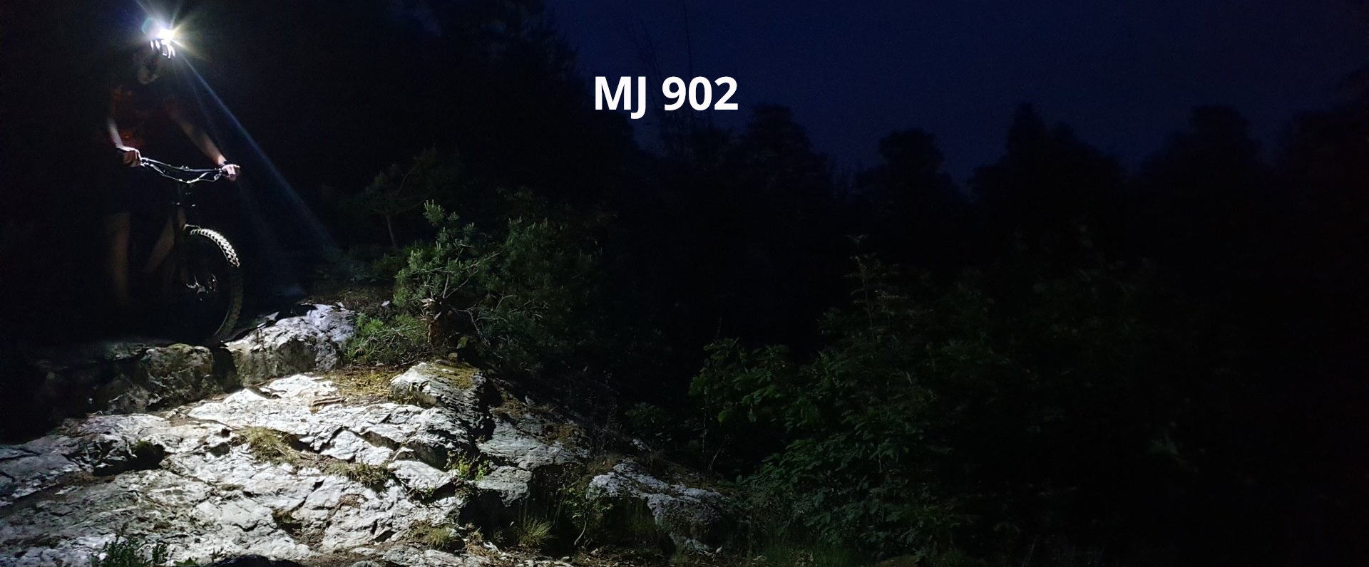 Magicshine Helmlampe MJ 902 mit Fahrradfahrer und Mountainbike im Wald auf Stein, sowie 1600 Lumen Leuchtkraft