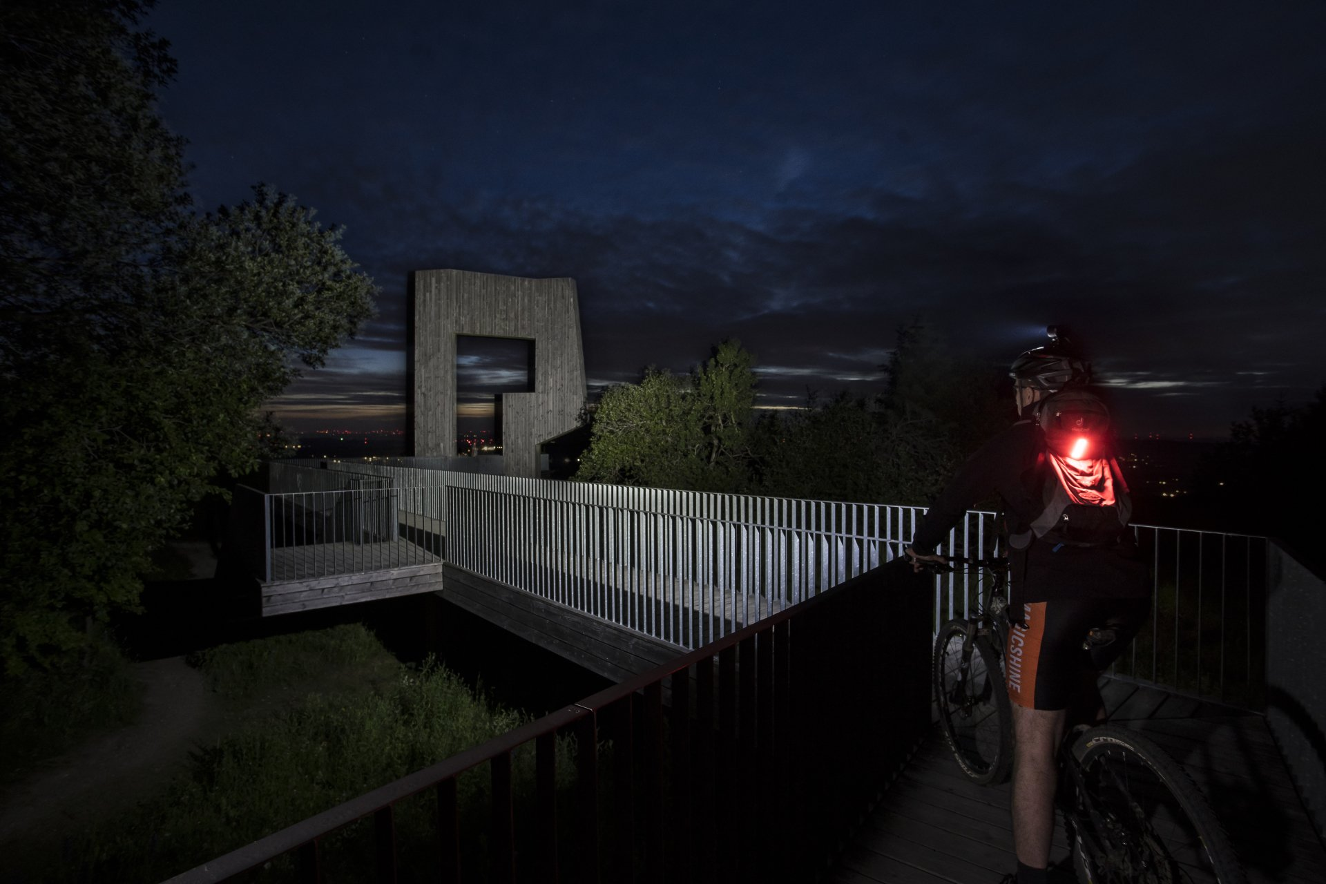 Magicshine Helmlampe Monteer 6500 mit 6 Leuchten bei Sonnenuntergang im Wald und auf der Wiese mit dem Fahrrad oder Mountainbike, offroad inklusive Rücklicht des Fahrradfahrers SeeMee 180