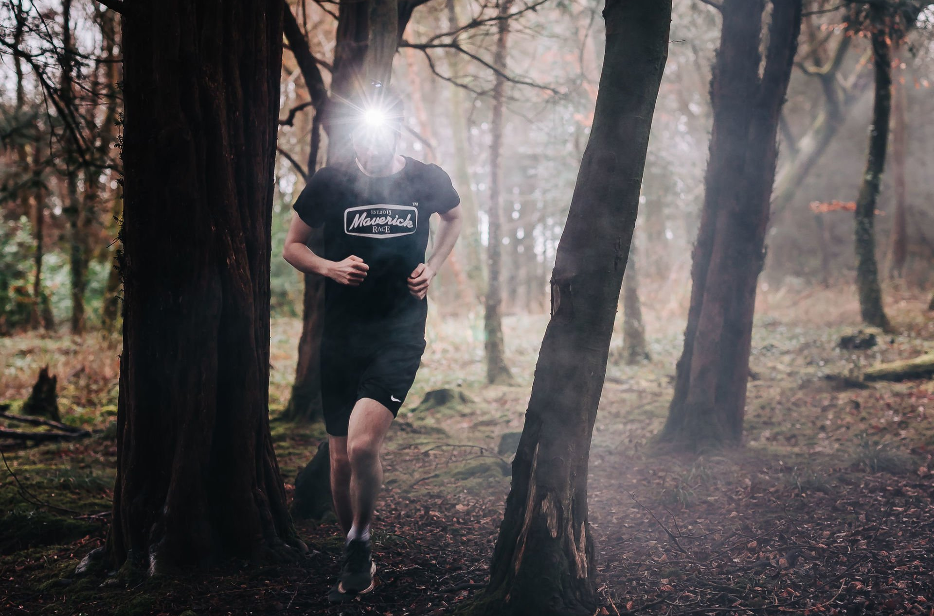 Magicshine leuchtstarke LED Lauflampe MOH 35, getragen von Läufer auf Kopf im Wald