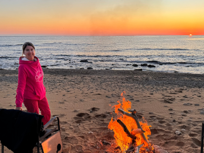 Sylvia Schnaider am Lagerfeuer am Strand, Vanlife im Winter auf einer einsamen griechischen Insel, F