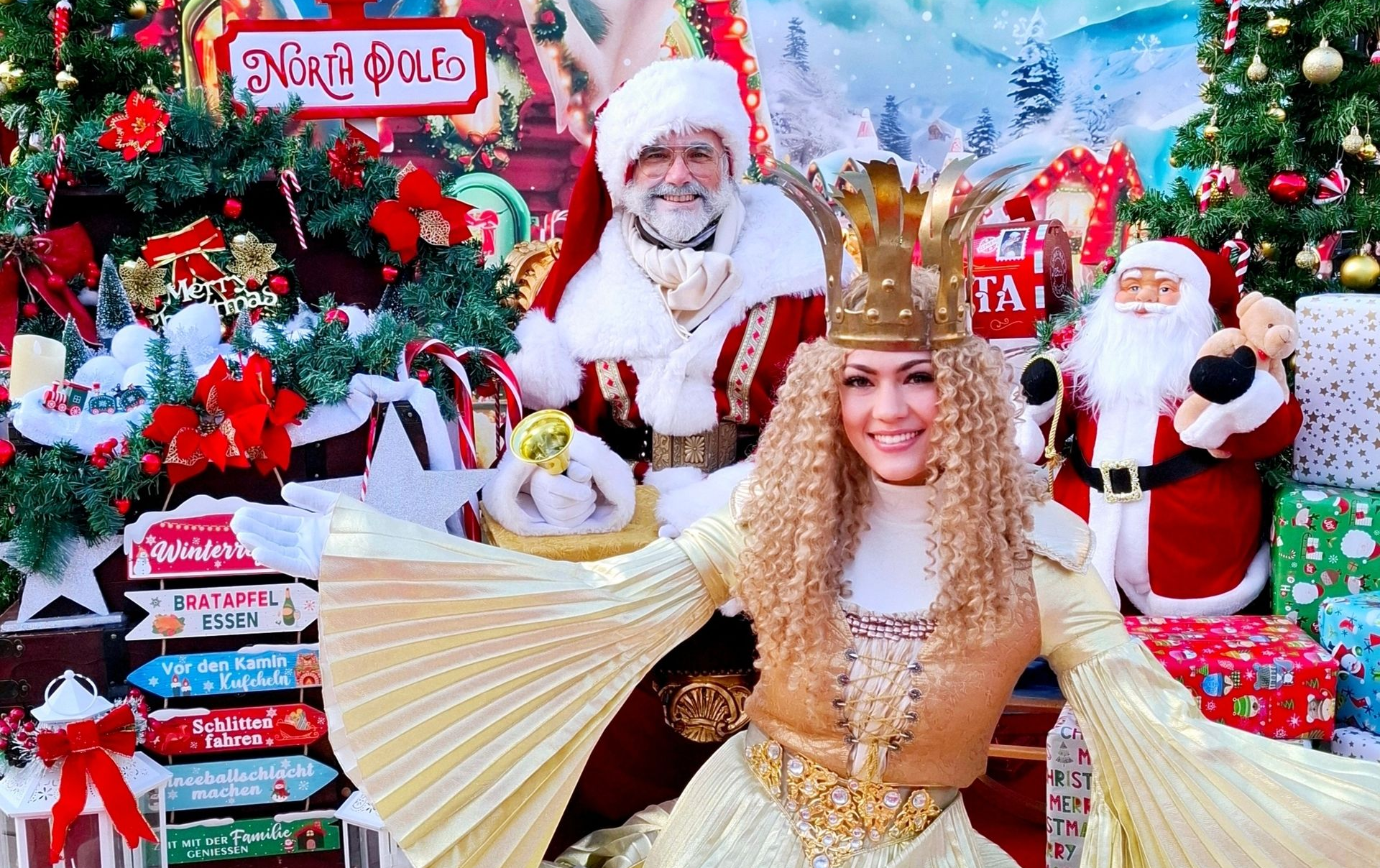 Weihnachtsmann begrüßt Besucher in festlich dekorierter Erlebniswelt