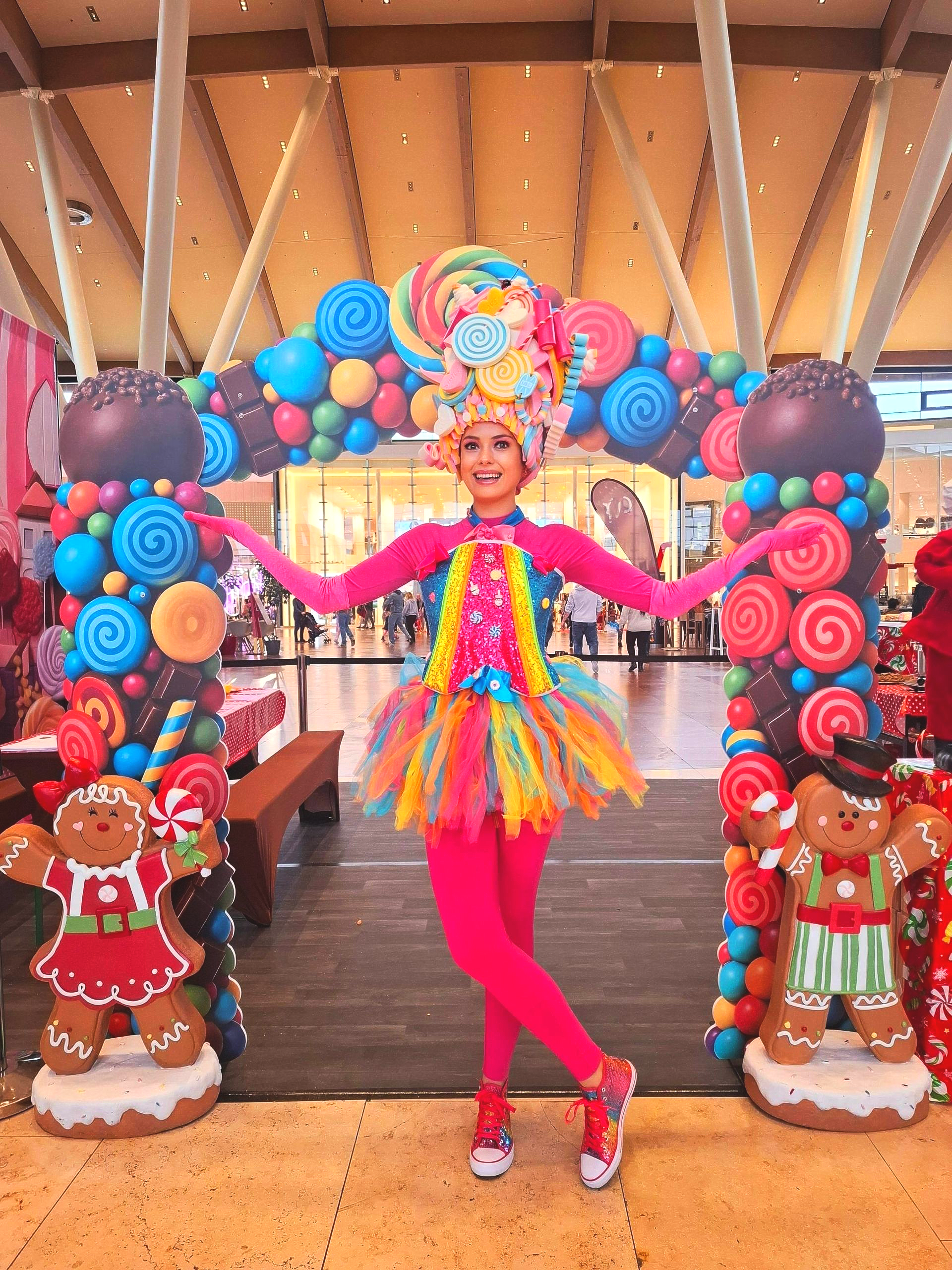 Mobiler Walking Act mit Candy Girl und rollendem Torbogen – ein interaktiver Eyecatcher für Messen, Events, Einkaufszentren und Publikumsmessen. Ideal für Besucheraktivierung, Fotospots und Social-Media-Reichweite. Candy Girl mit rollendem Candy-Torbogen als mobiler Walking Act auf einer Messe zur Besucheraktivierung, Besucherinteraktion und Steigerung der Verweildauer durch ein einzigartiges Besuchererlebnis.