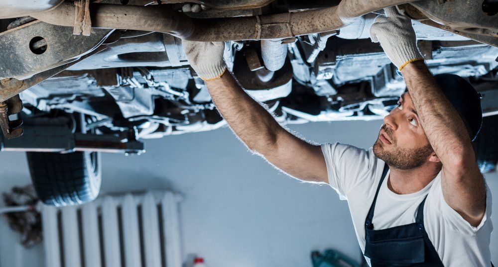 KFZ-Mechaniker Bild eines KFZ-Mechanikers, der ein Auto repariert als Beispiel für einen Gewerbetreibenden