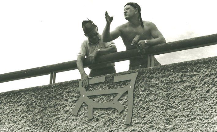 Zwei Männer auf einer Brücke, nackter Oberkörper, Akkuschrauber, Piratentuch, Hut