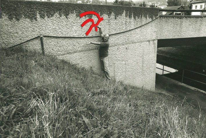 Mann zeigt auf ein rotes Zeichen an der Wand