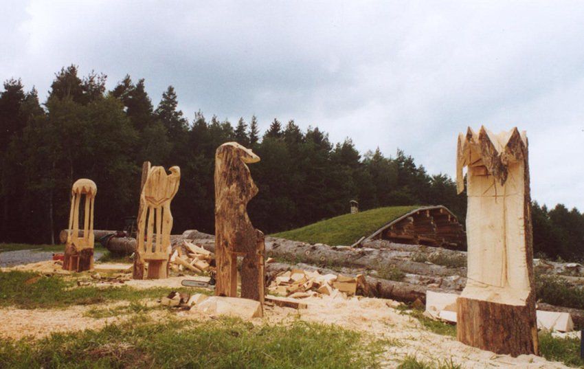 Holzskulpturen vor Erdhaus