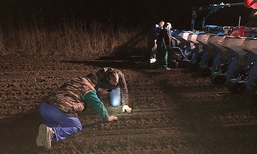 Feld-Kontrolle der Saat im Boden mit Sämaschine nachts durch Landwirt, Ackerbauberater und Mechaniker für Landtechnik in Rumänien, Osteuropa