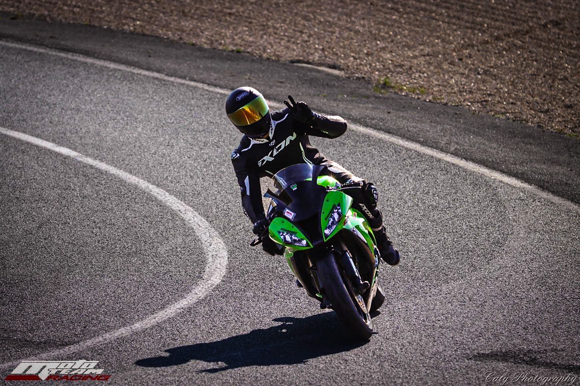 Photo d'un motard sur le piste qui salue