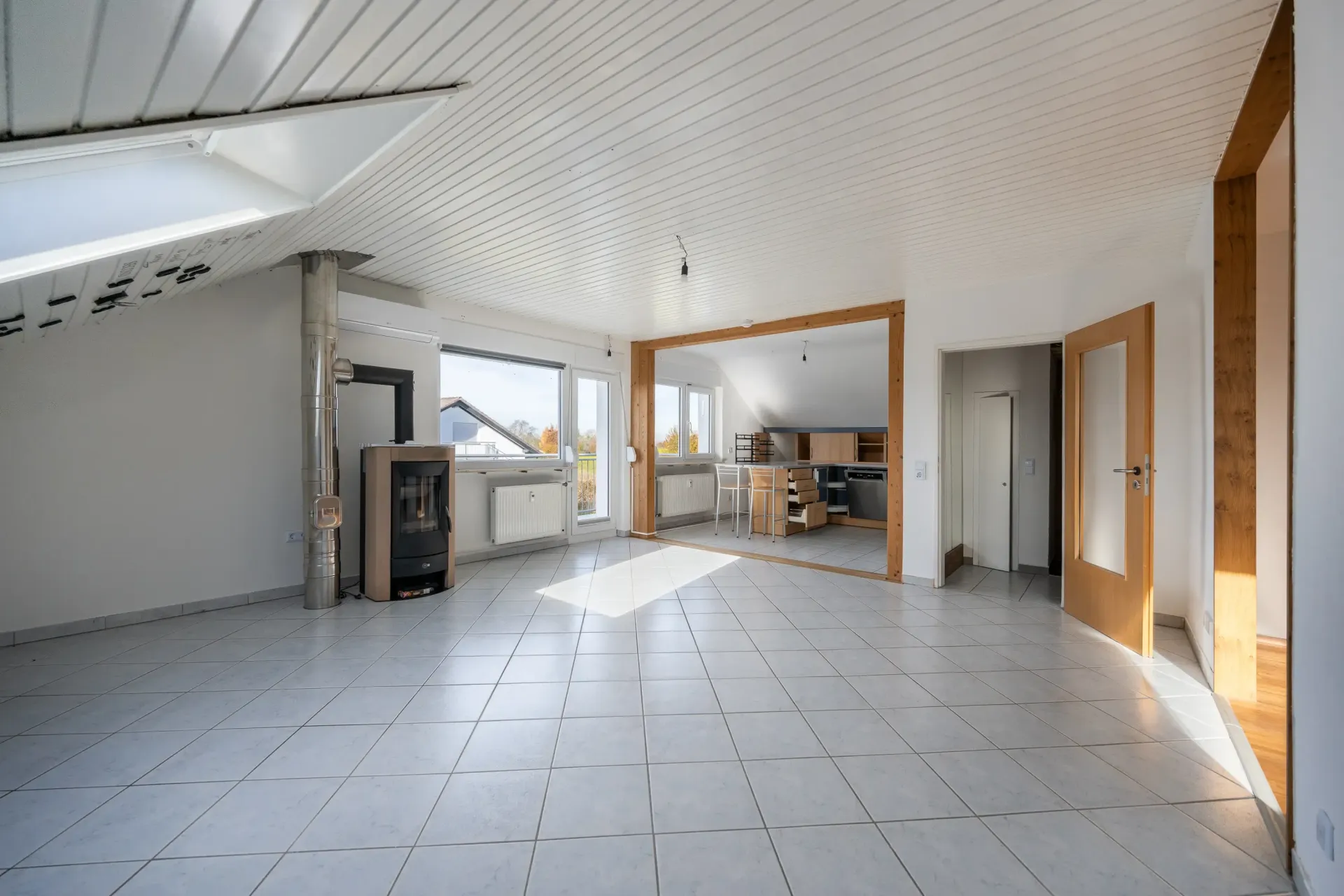 Wohnzimmer mit Kamin, offener Küche und Zugang auf den Balkon in KA-Palmbach